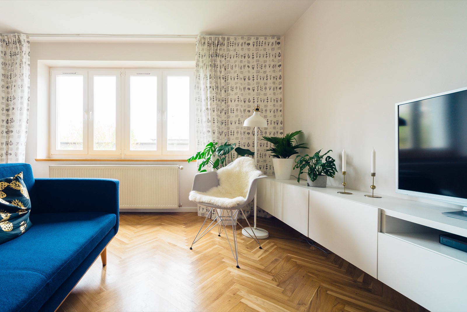 Living room with a blue sofa and a herringbone floor