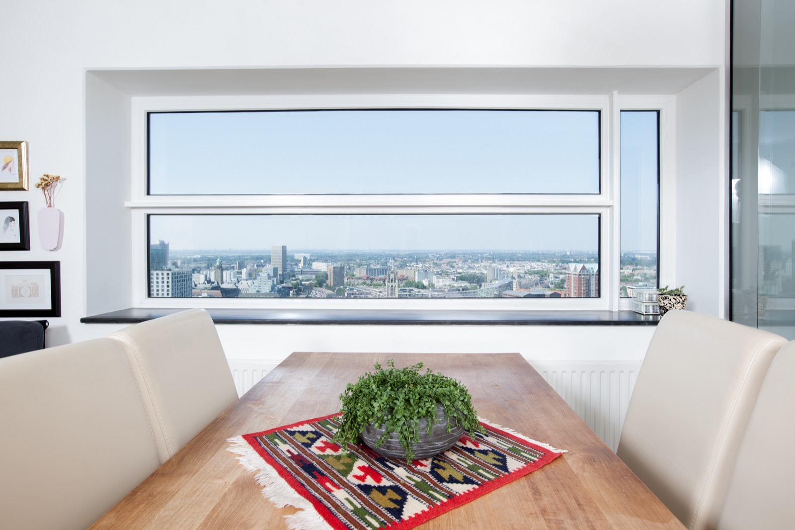 Dining table beside a floor-to-ceiling skyline window