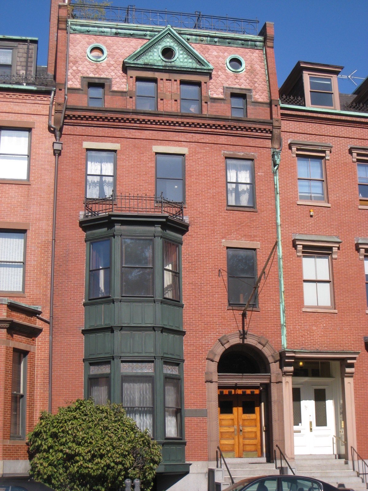 Narrow brick town house with a stone stoop