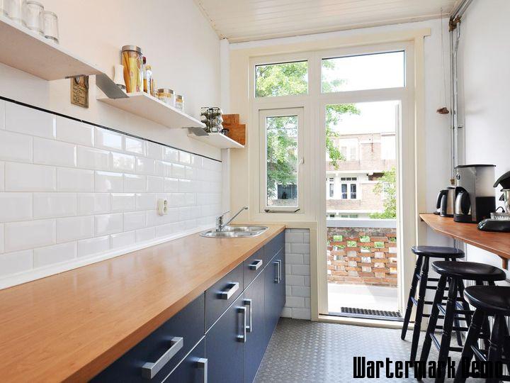 Five-Bedroom Town House on Rue de Rivoli - Galley kitchen with navy units, an oak worktop and a glazed door to the terrace