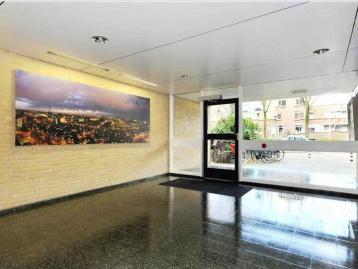 Five-Bedroom Town House on Rue de Rivoli - Entrance hall with a glazed street door and a framed cityscape on the brick wall