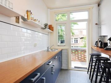Five-Bedroom Town House on Rue de Rivoli - Galley kitchen with navy units, an oak worktop and a glazed door to the terrace